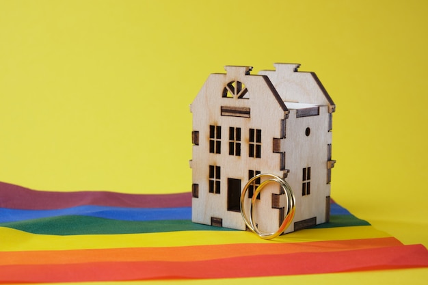 anillos de boda y modelo de casa de madera y bandera lgbtq