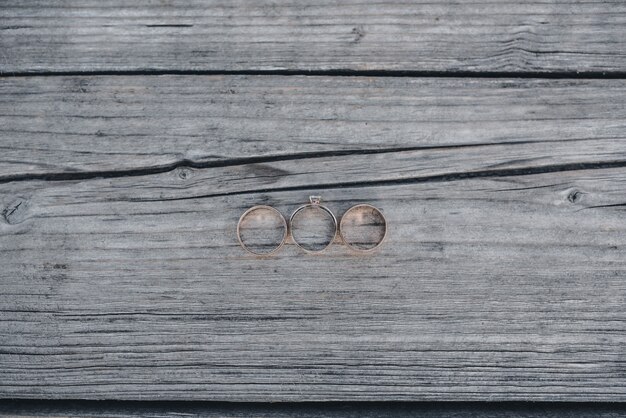 Anillos de boda para el novio y la novia en el fondo de madera