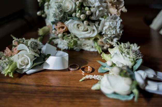 Anillos de boda de oro cerca del ramo de la novia.