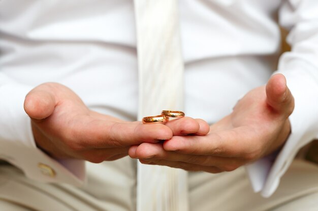 Foto anillos de boda de oro en una mano del novio