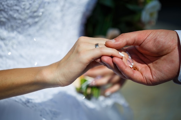 Anillos de boda de oro en manos de los recién casados