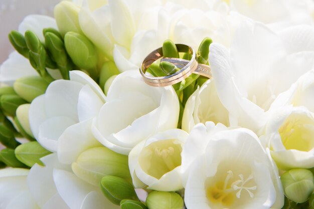 Anillos de boda de oro en un ramo de flores.