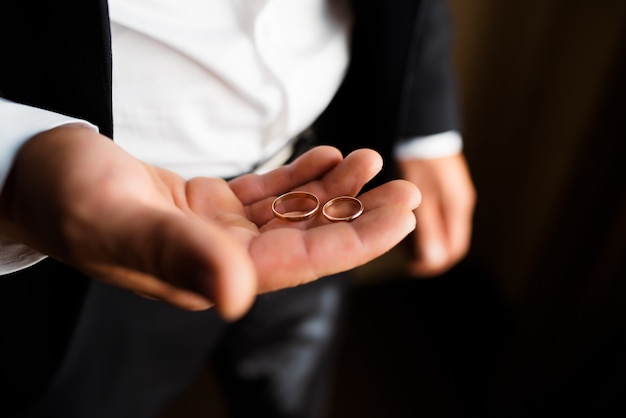 Anillos de boda en la palma del novio.