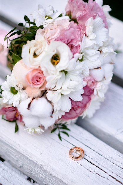 Foto anillos de boda y ramo en el fondo