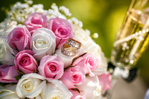 Anillos de boda con rosas y copas de champagne