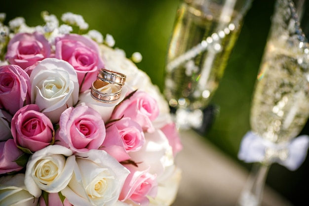 Anillos de boda con rosas y copas de champagne