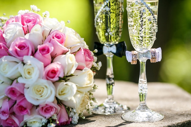 Anillos de boda con rosas y copas de champagne