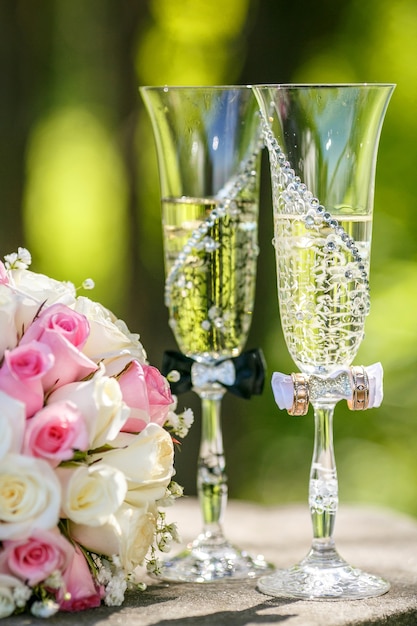 Anillos de boda con rosas y copas de champagne