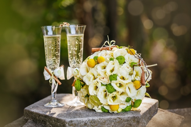 Anillos de boda con rosas y copas de champaña