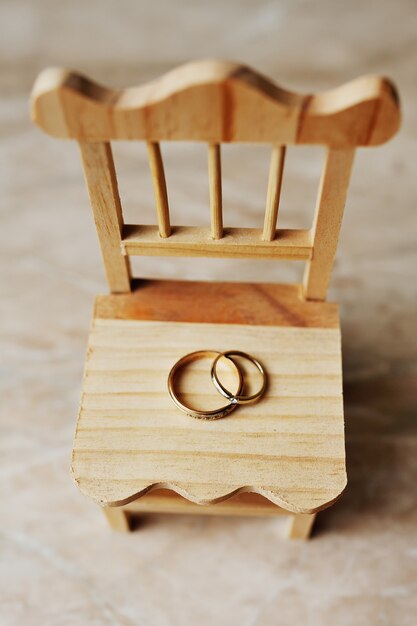 Foto anillos de boda en una silla de madera