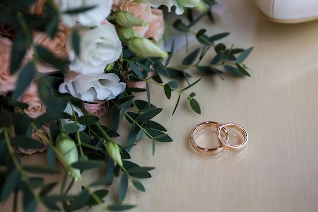 Los anillos de boda yacen cerca de un hermoso ramo como accesorios nupciales