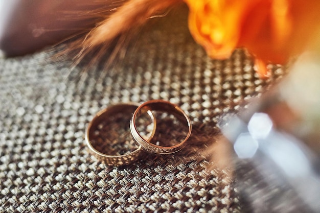 Los anillos de boda yacen sobre la mesa cerca de un ramo de novia