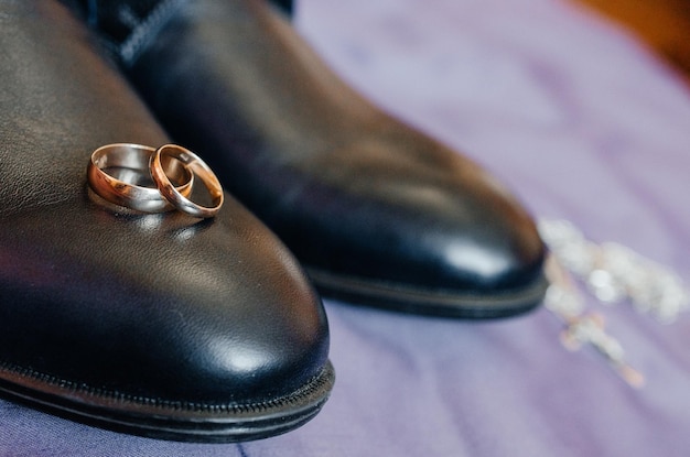 los anillos de boda yacen en los zapatos de los hombres negros