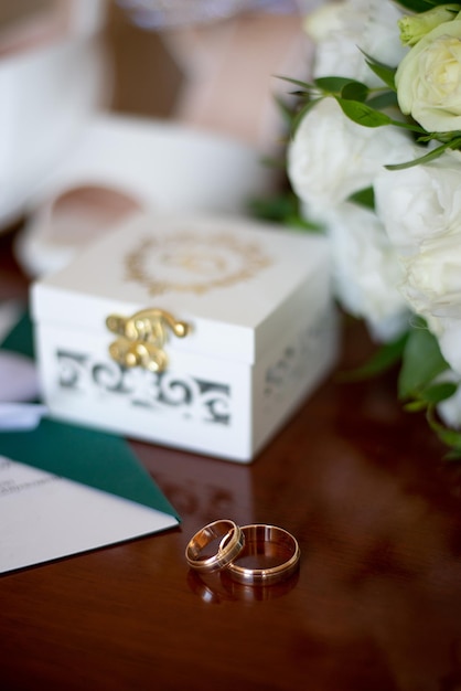 Foto anillos de boda y zapatos en el fondo de una idea de ramo para agencias de eventos
