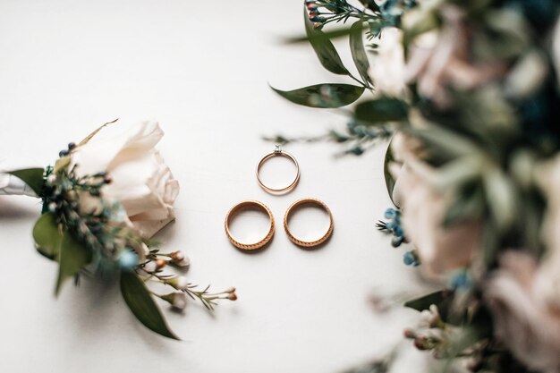 Foto los anillos de bodas están con flores frescas