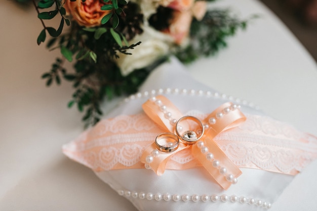 Los anillos de bodas de oro como atributo de la boda de una pareja joven