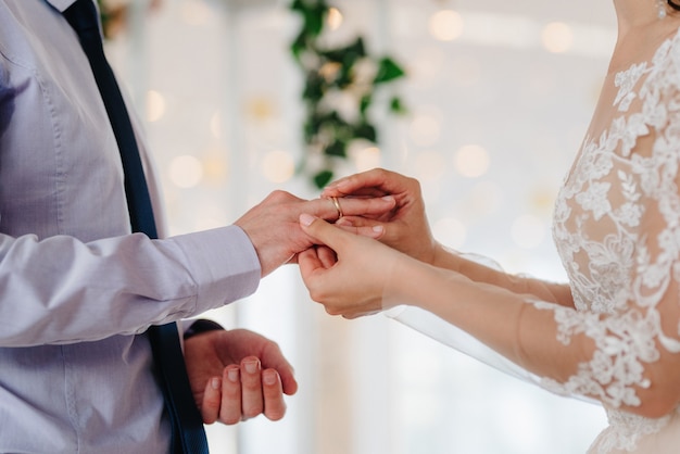 Los anillos de bodas de oro como atributo de la boda de una pareja joven