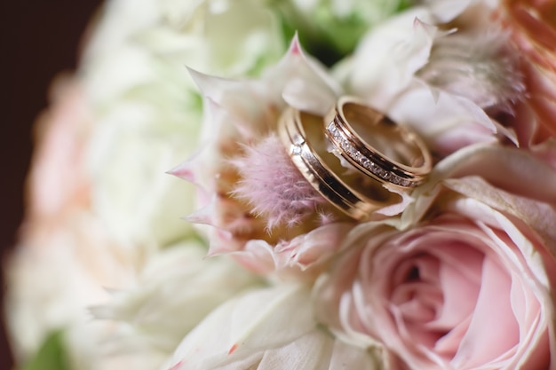 Anillos de bodas de oro en la rosa blanca de la boda