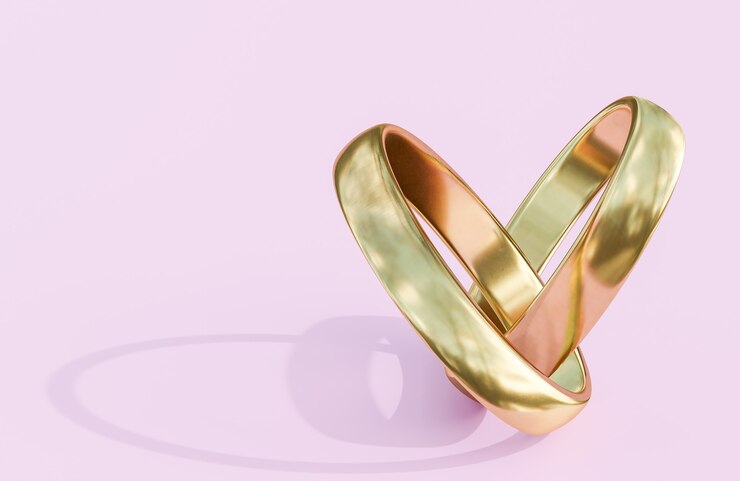 Anillos de bodas de oro sobre fondo rosa