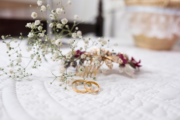 Anillos de compromiso para una boda con pequeñas flores detrás.