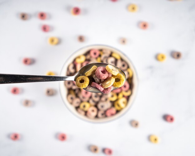 Anillos de desayuno de cereales Coloful bucles en un tazón con cuchara