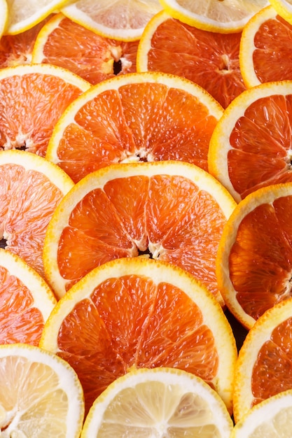 Los anillos jugosos frescos de la fruta de la naranja y del limón se cierran encima de fondo.