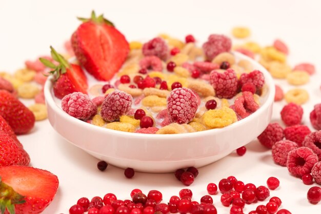 Anillos de maíz con leche en un plato con bayas y frutas.