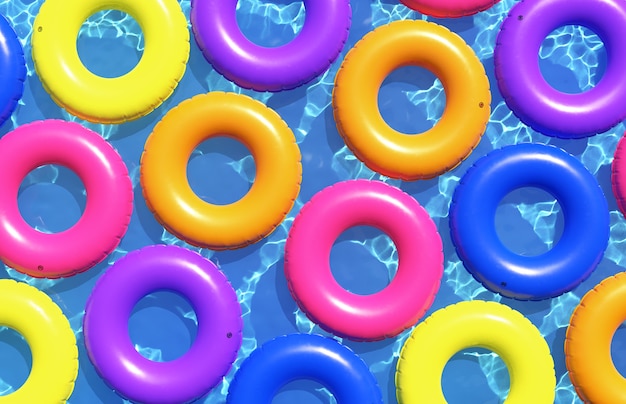 Anillos de natación coloridos en el fondo del agua azul