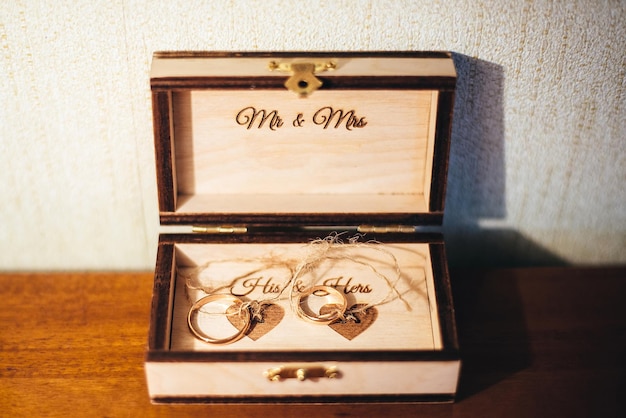 Anillos de oro de boda en una caja ceremonia de boda reuniendo a la novia y el novio en la mesa señor y señora familia joven feliz día amor y para siempre juntos