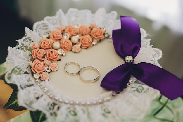 Anillos de oro de boda sobre una almohada blanca