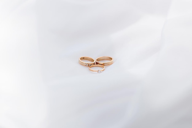 Anillos de oro de boda sobre un fondo blanco juego de minimalismo de luz y sombra lugar para texto