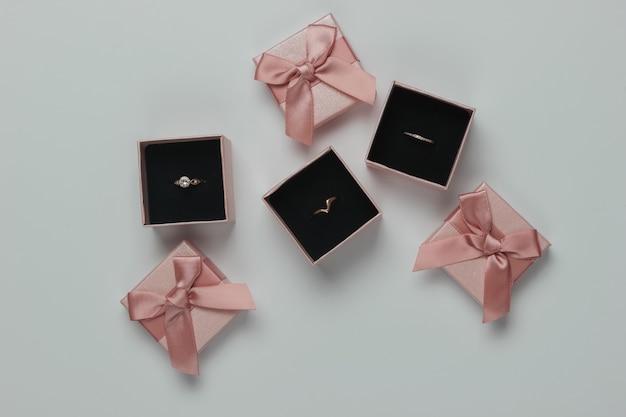 Foto anillos de oro en cajas de regalo sobre fondo blanco. joyería. vista superior