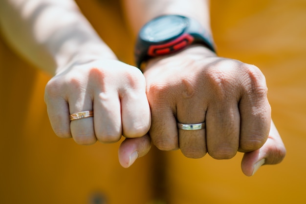 Foto anillos de pareja cogidos de la mano con fondo borroso