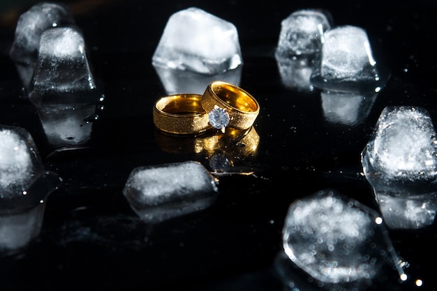 Anillos sobre un fondo oscuro. Anillos de boda. Joyas. Hielo