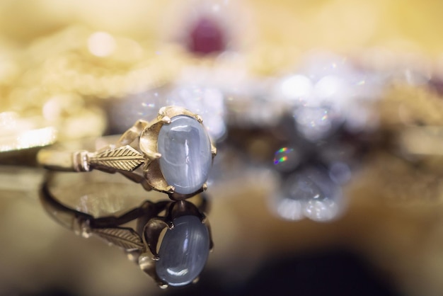 Foto anillos de zafiro azul de joyería de oro vintage con reflexión sobre fondo negro