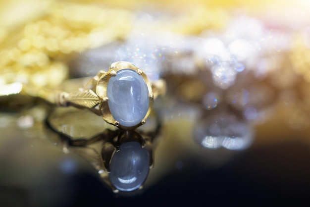 Anillos de zafiro azul de joyería de oro vintage con reflexión sobre fondo negro