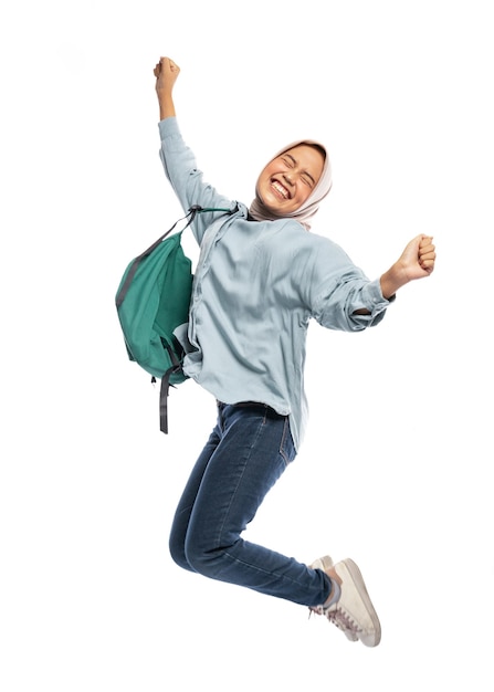 Foto animada estudante universitária muçulmana pulando de alegria com mochila em fundo isolado