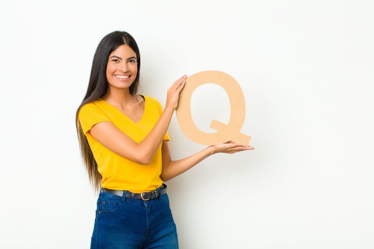 Foto animado, feliz, alegre, segurando a letra q do alfabeto para formar uma palavra ou frase.