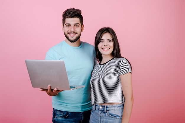 Animado feliz sorridente jovem casal homem e mulher, juntamente com o laptop