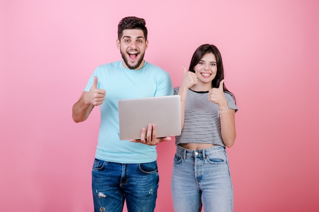 Animado feliz sorridente jovem casal homem e mulher, juntamente com o laptop