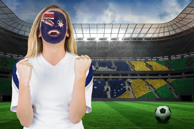 Foto animado torcedor australiano com pintura facial torcendo contra um grande estádio de futebol com torcedores brasileiros