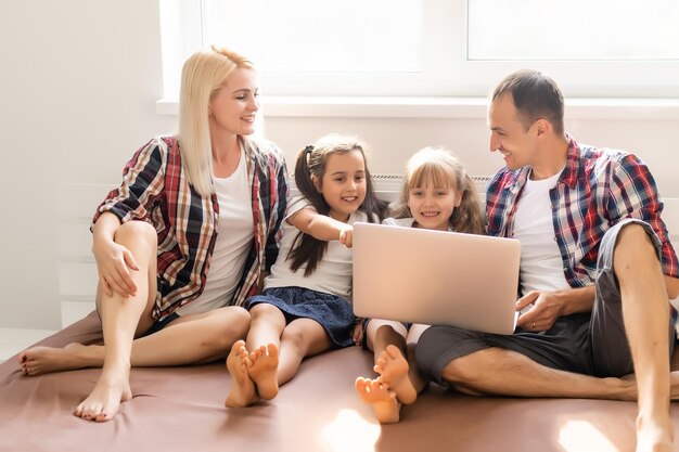 Animierte Familie, die online zu Hause auf dem Bett einkauft