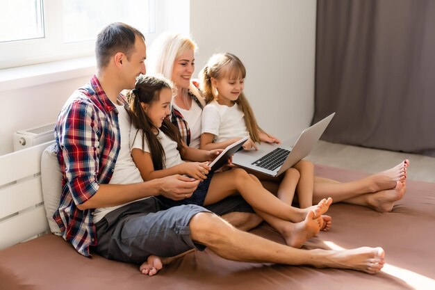 Animierte Familie, die online zu Hause auf dem Bett einkauft