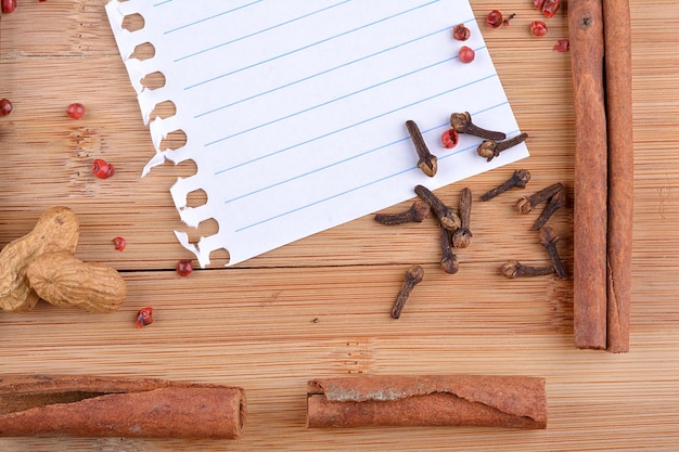 Foto anís estrellado de canela de papel y clavo de olor sobre madera