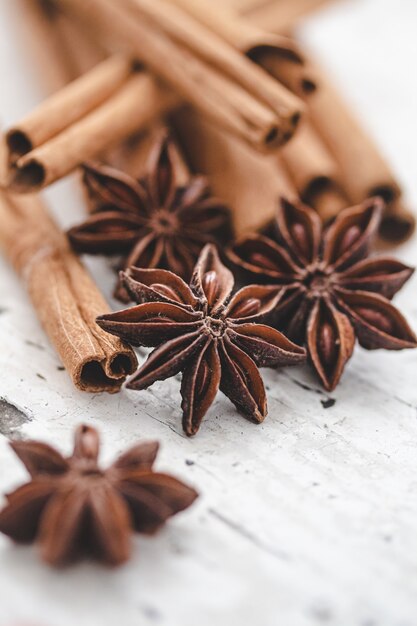 Anís estrellado y canela sobre fondo blanco de madera