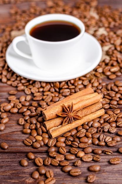 Anisstern auf Zimtstangen mit gerösteten Arabica-Kaffeebohnen auf hölzernem Hintergrund.