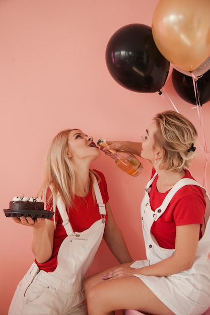Aniversario de la amistad. Dos chicas celebrando beben champán. Fondo festivo.