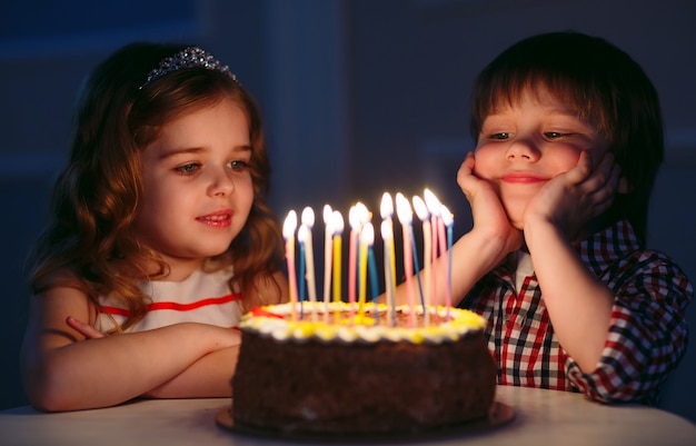 Aniversário das crianças. crianças perto de um bolo de aniversário com velas.