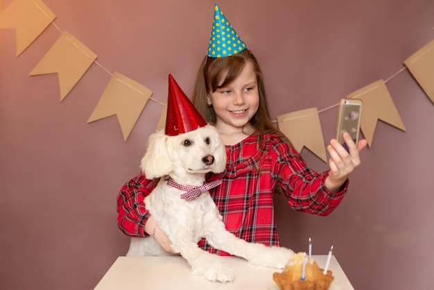 aniversário de um cachorro e uma criança uma festa para um cachorro de chapéu e sentou-se ao telefone