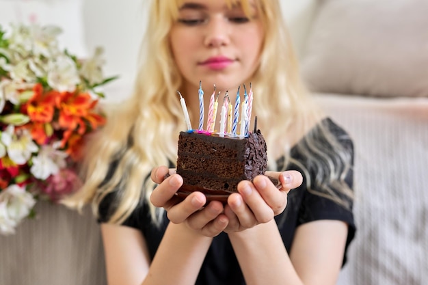 Aniversário de uma adolescente feminina com bolo pequeno de aniversário com velas apagadas